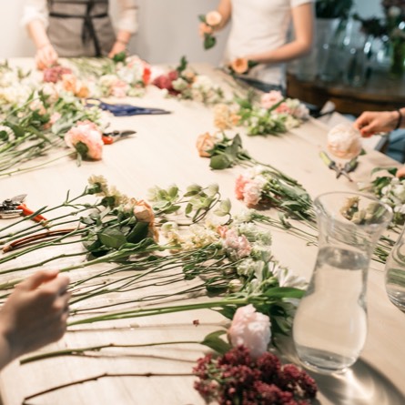 Des personnes autour d'une table pendant le cours d'art floral chez Fleuri’styl